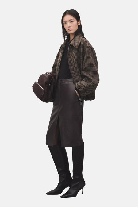 Zwart T-shirt met lange mouwen van MANGO, hooggesloten en gestyled met een bruin geruit jack en een donkerbruine leren rok.