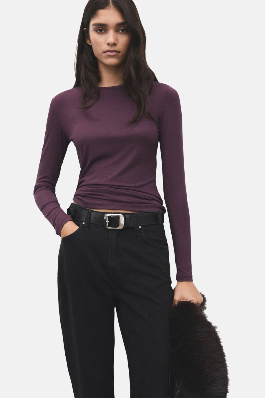 Bordeaux T-shirt met lange mouwen van MANGO, gedragen met zwarte jeans en een zwarte riem met zilveren gesp.