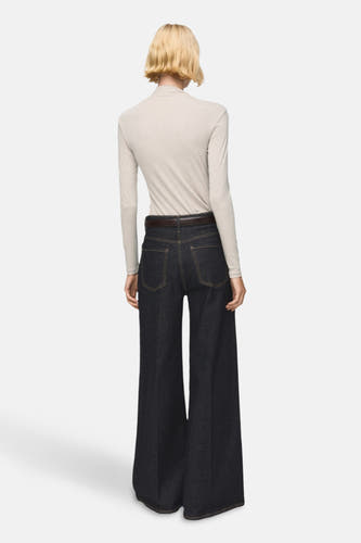 Beige T-shirt met lange mouwen van MANGO, gezien van achteren met een donkere broek en bruine riem.
