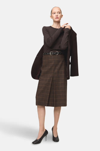 Bruin T-shirt met lange mouwen van MANGO, gedragen met een geruite rok en een zwarte riem.