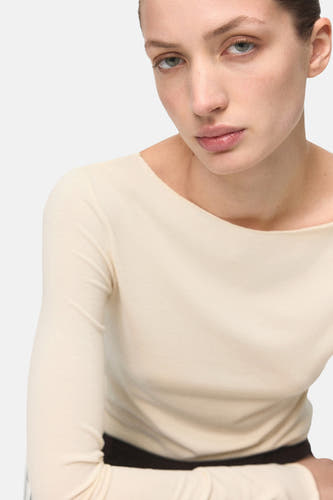 Ecru T-shirt met lange mouwen van MANGO, getoond in een cropped close-up.
