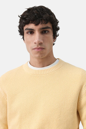 Pull jaune à col rond de MANGO, avec une fine texture gaufrée et un haut blanc en dessous.