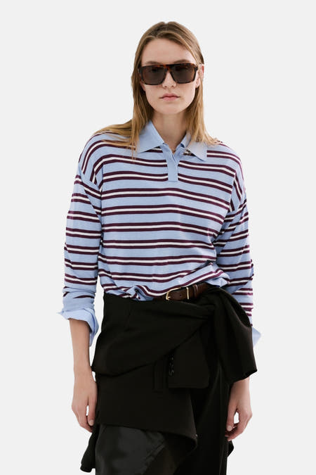 Multikleurige trui met ronde hals van MANGO, met gestreepte patronen en een polo kraag, gestyled met zonnebril en een zwarte jas.
