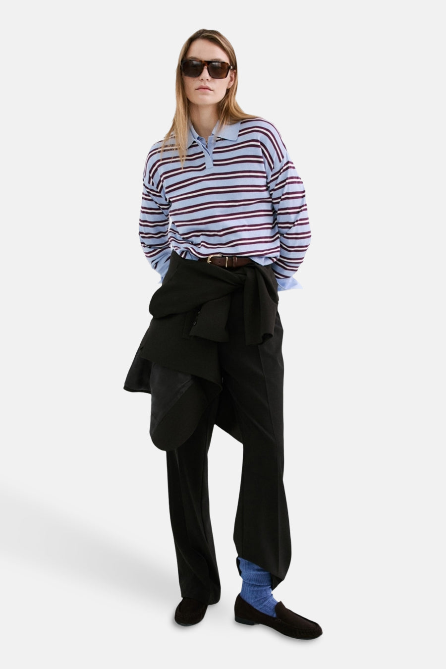 Pull multicolore à col rond de MANGO, rayé et porté avec une chemise à col et un pantalon noir.