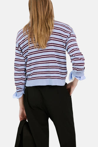 Multikleurige pull met ronde hals van MANGO, met horizontale strepen in blauw en bordeauxrood, gedragen met een zwarte broek.