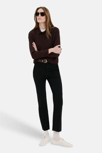 Pull Bordeaux à col rond de MANGO, à manches longues et coupe droite, porté avec un pantalon noir et des chaussures blanches.