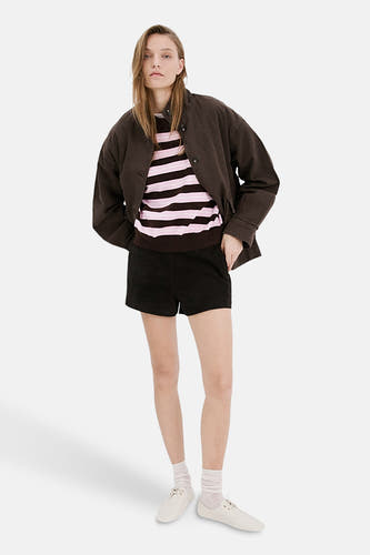 Pull multicolore à col rond de MANGO, avec des rayures horizontales roses et marron, combiné avec une veste marron et un short noir.