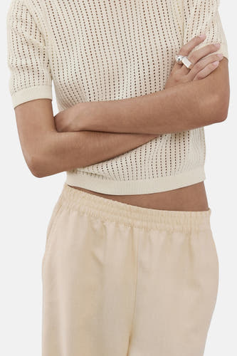 Pull beige à col rond de MANGO, à manches courtes et à texture ajourée.
