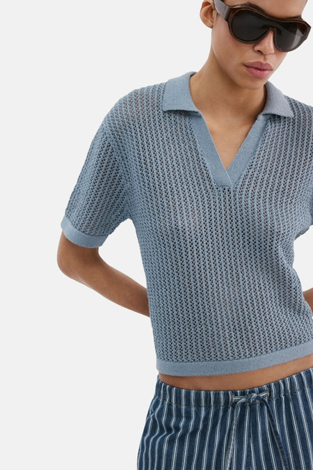 Blauwe polo met korte mouwen van MANGO, met een opengebreide textuur en een klassieke kraag.