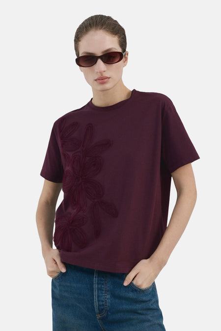 T-shirt Bordeaux à manches courtes de MANGO, avec une coupe décontractée et un jean à jambes larges.