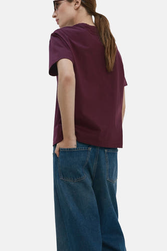 Bordeaux T-shirt met korte mouwen van MANGO, met een losse pasvorm en jeans met wijde pijpen.
