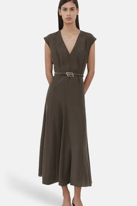 Robe marron sans manches de MANGO, avec une fine ceinture et portée avec des sandales marron.