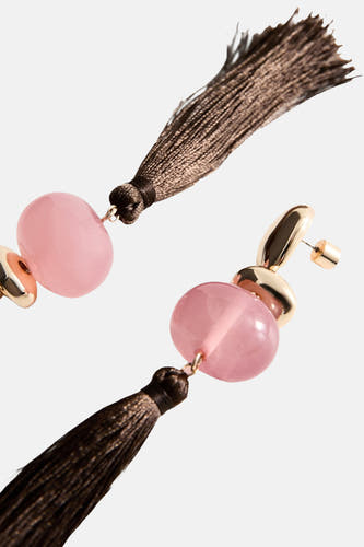Multikleurige oorringen van MANGO, met roze stenen en bruine kwasten, in een schuine weergave.
