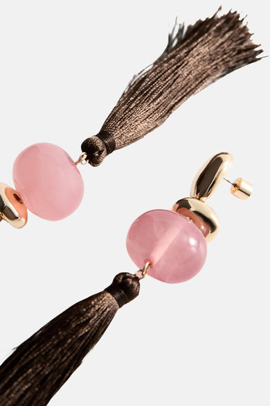 Multikleurige oorringen van MANGO, met roze stenen en bruine kwasten, in een schuine weergave.

