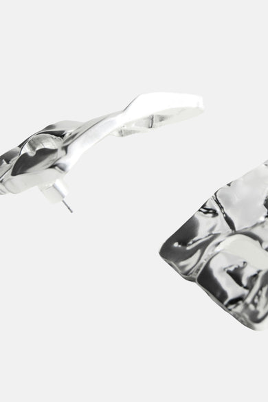 Boucles d'oreilles argentées de MANGO avec une texture martelée et un design asymétrique.