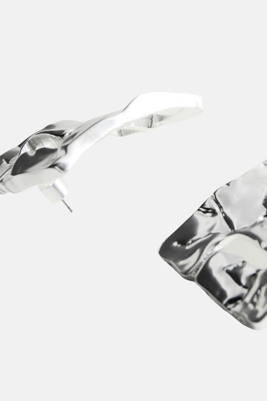 Zilverkleurige oorringen van MANGO met een gehamerde textuur en een asymmetrisch ontwerp.