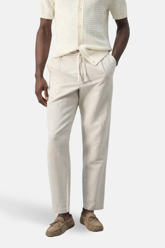 Ecru broek van MANGO, met trekkoord en steekzakken, gecombineerd met suède mocassins en een gebreid overhemd.