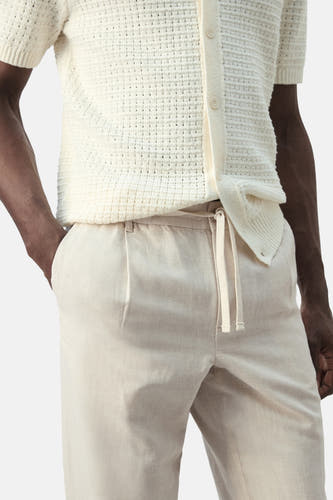 Ecru broek van MANGO, met trekkoord in de taille en plooien aan de voorkant.