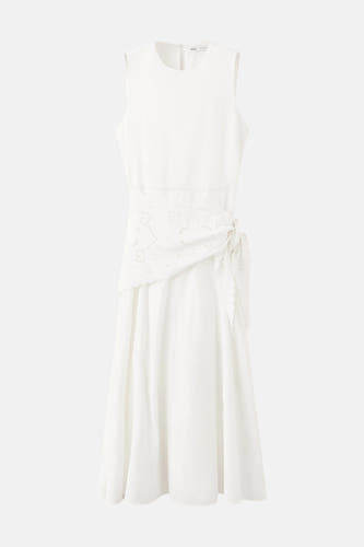 Robe sans manches écru de MANGO avec encolure ronde, ceinture brodée et nœud sur le côté.