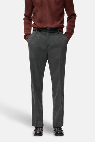 Pantalon gris de MANGO, vu de de l'arrière, avec une ceinture et porté avec un pull marron rougeâtre.