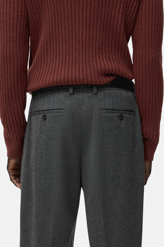 Pantalon gris de MANGO, avec poches passepoilées et une ceinture noire.