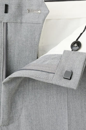 Pantalon de costume gris MANGO, avec une fermeture à glissière et une texture subtile.