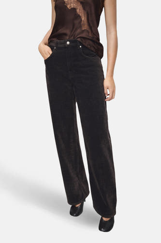 Pantalon marron de MANGO, large en bas, avec des poches arrière et associé à un haut marron avec des détails bordés.