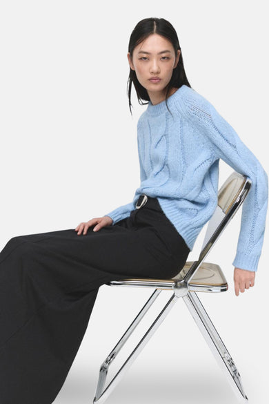 T-shirt bleu avec col rond de MANGO, à motif côtelé et longues manches, porté avec une longue jupe noire.
