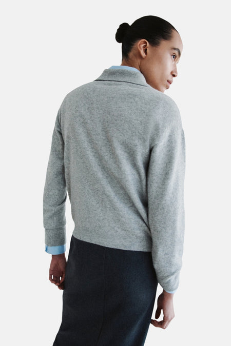 Grijze trui en donkergrijze rok, achterkant.