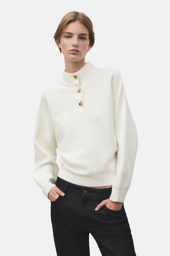 Sweat-shirt écru de MANGO avec col montant, manches longues et texture rayée, associé à un jeans foncé.
