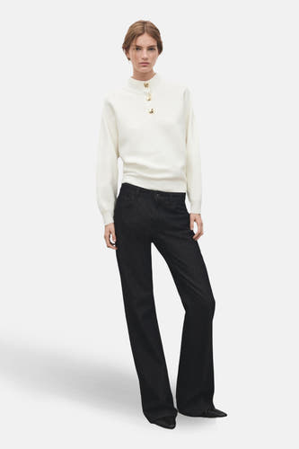 Couleur écru de MANGO, avec des boutons dorés à la taille, associée à un jean foncé.