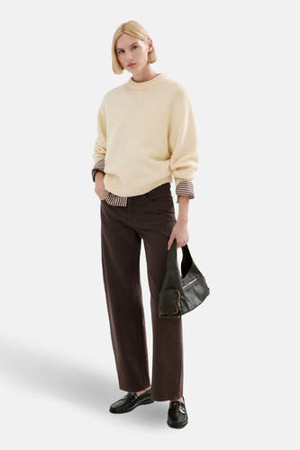 Jean bleu de MANGO, associé à une chemise crème et des mocassins en cuir.