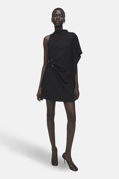 Zwarte mouwloze jurk van MANGO, met een asymmetrische halslijn en een decoratieve drapering aan de zijkant.