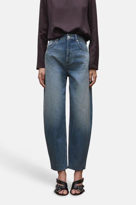 Jeans met speciale pasvorm, in blauw denim van Mango, met een verloop en gedragen met zwarte sandalen.
