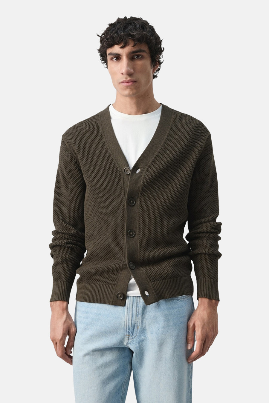 Gilet marron de MANGO, texturé, vu de dos, porté avec un jean bleu clair.