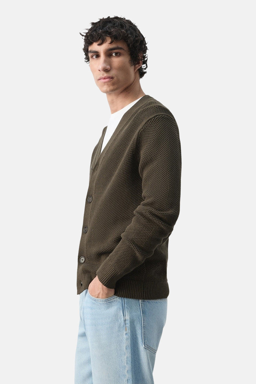 Gilet marron de MANGO avec fermeture à boutons, porté sur un T-shirt blanc et un jean clair.