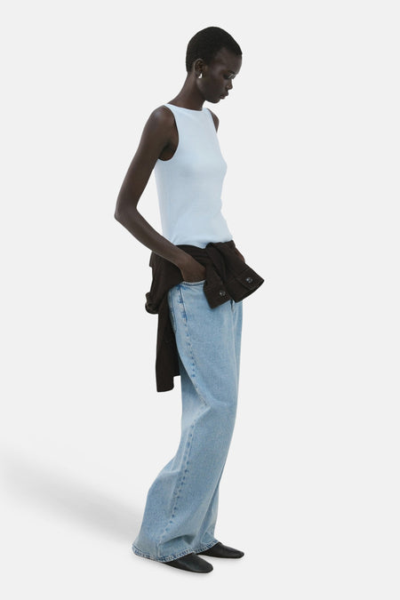 Haut bleue sans manches de MANGO, avec un décolleté droit, combinée avec un jean ample et une veste marron.