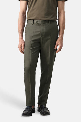 Pantalon kaki de MANGO, vu de dos, avec poches italiennes et chaussures habillées.