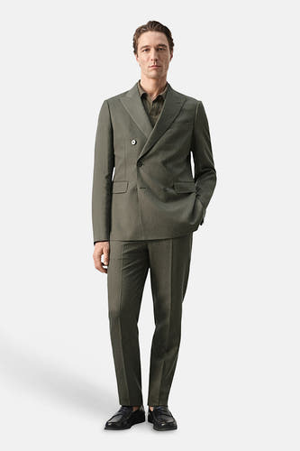 Pantalon kaki de MANGO, combiné avec un blazer croisé vert et des chaussures noires.