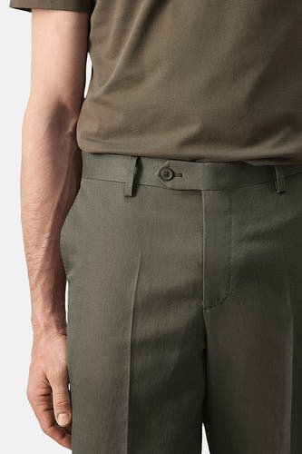 Pantalon kaki de MANGO, avec une fermeture à boutons et de subtils plis à l'avant.