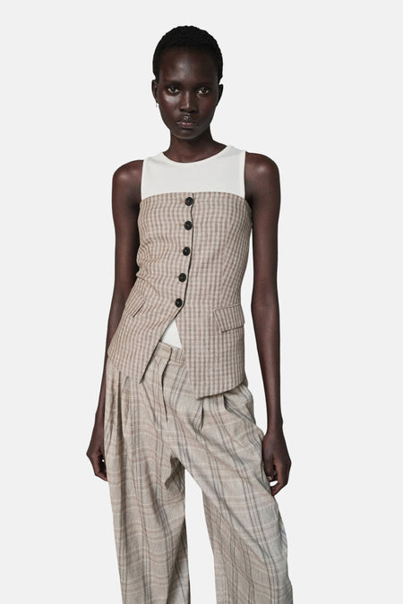 Naturelkleurige geruite mouwloze blouse van MANGO, met knoopsluiting en klepzakken, over een wit T-shirt.