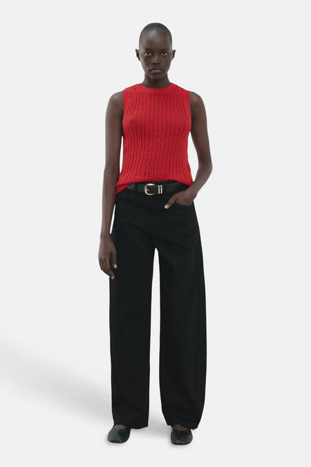 Mouwloze rode top van MANGO, met een open gebreide textuur en gecombineerd met een zwarte broek en riem.