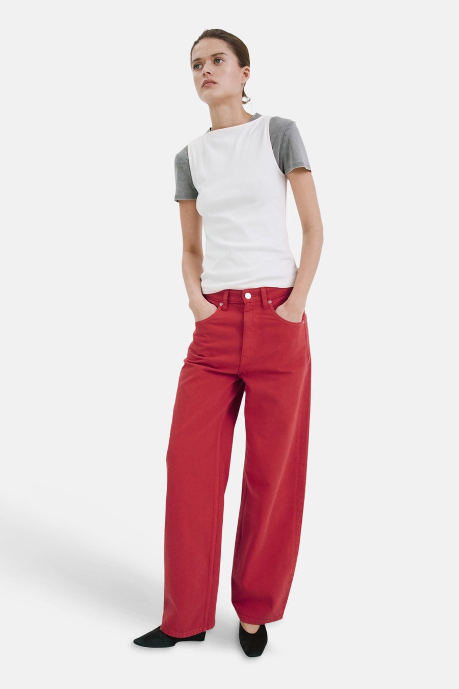 Jean de couleur rouge de MANGO à jambes larges, porté avec un t-shirt blanc cassé et des chaussures noires.