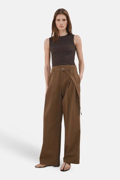 Bruine mouwloze top van MANGO met getextureerde stof en subtiele glinstering, gedragen met bruine wijde broek.