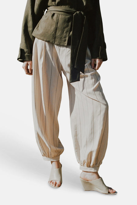 Ecru broek van MANGO met dunne verticale strepen, wijde pasvorm en elastische enkels.