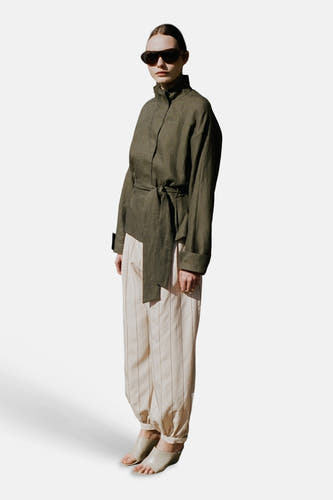 Ecru broek met strepen van MANGO, in linnenstijl met een losse pasvorm en geplooide enkels, gedragen door een model.