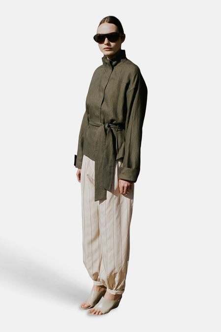 Ecru broek met strepen van MANGO, in linnenstijl met een losse pasvorm en geplooide enkels, gedragen door een model.