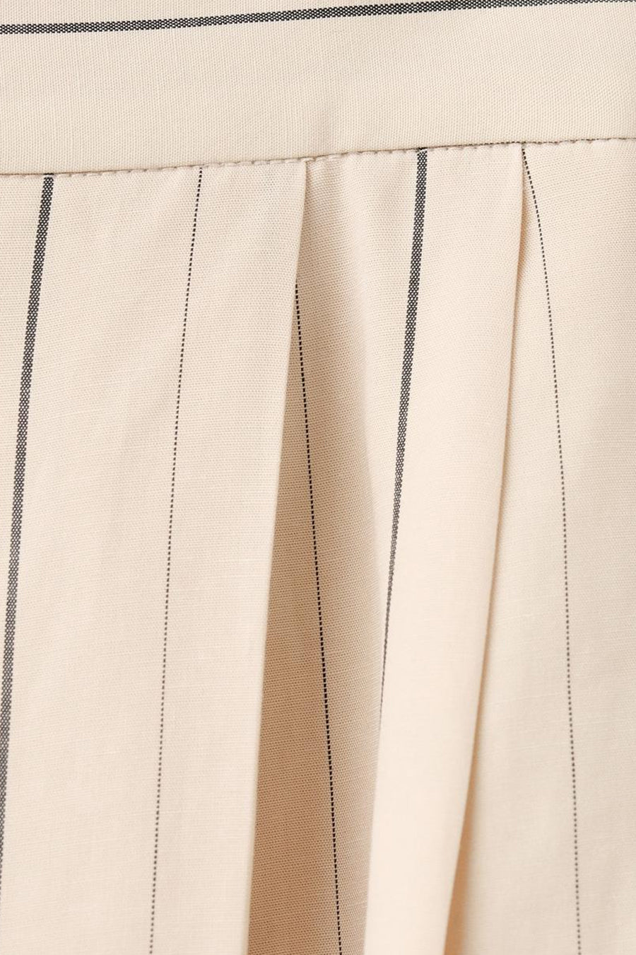 Ecru broek van MANGO met krijtstrepen en plooien, close-up.