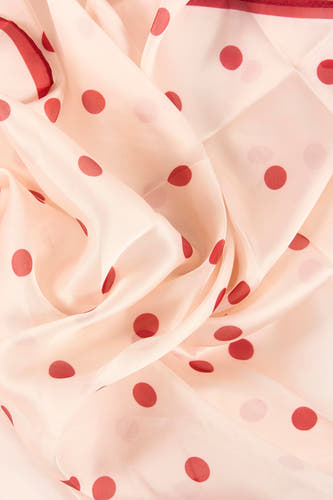 Lichtroze zomersjaal van MANGO met rode polkadots, golvend gedrapeerd.