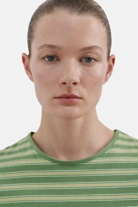 Groen gestreept T-shirt van MANGO met gele en witte horizontale strepen, gedragen door een model.